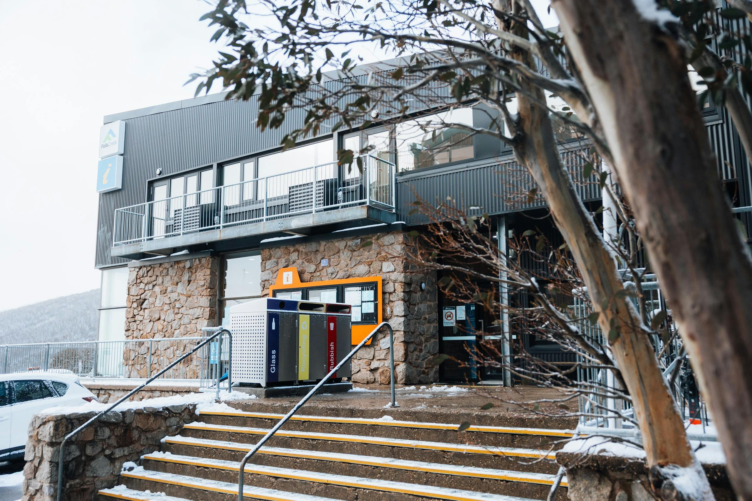 Concrete steps leading up to the flat access ramp in front of the two-story building.