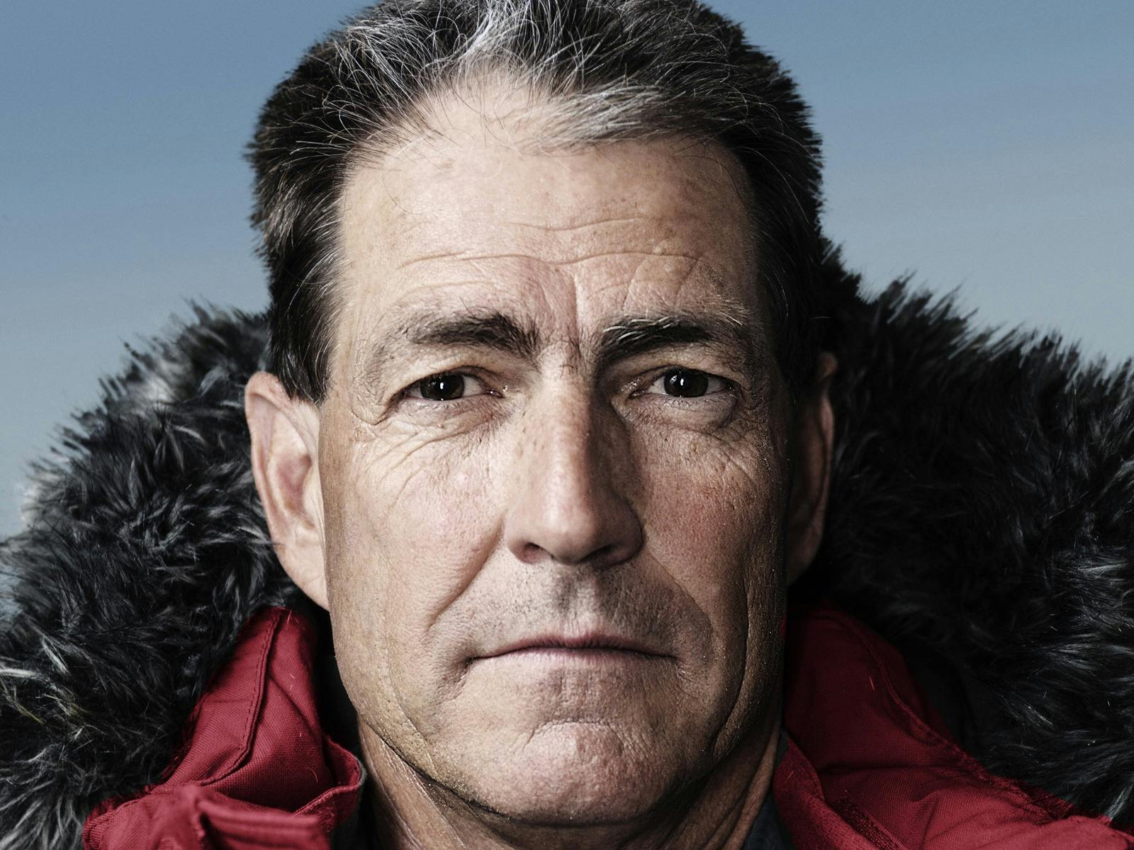 Headshot of Professor John Priscu in a red, weatherproof jacket with hood,