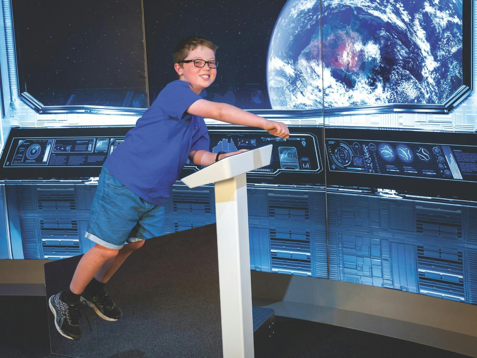 A boy interacts with a space exhibit at the Australia in Space museum exhibition
