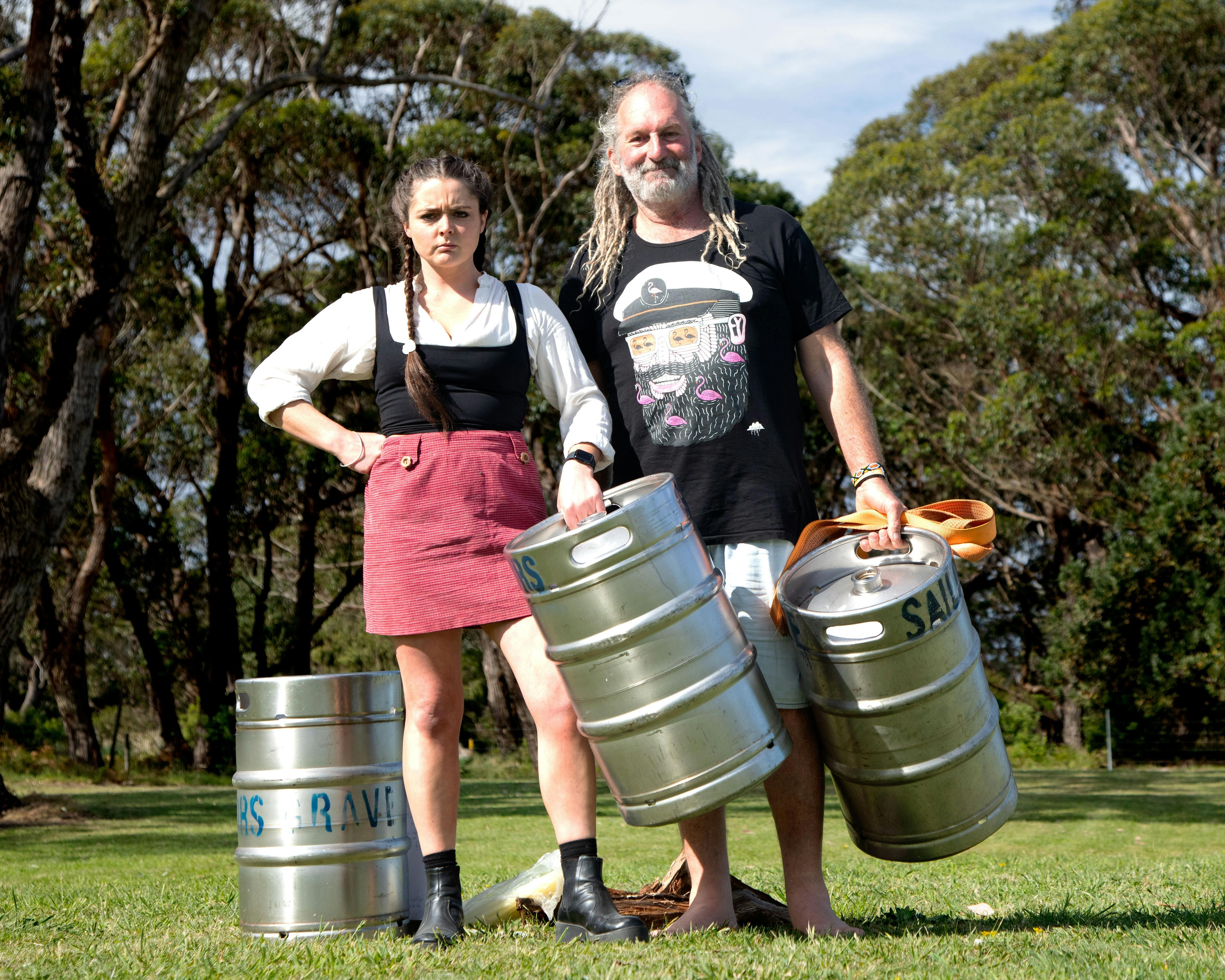Two peole holding kegs for keg-throwing competition
