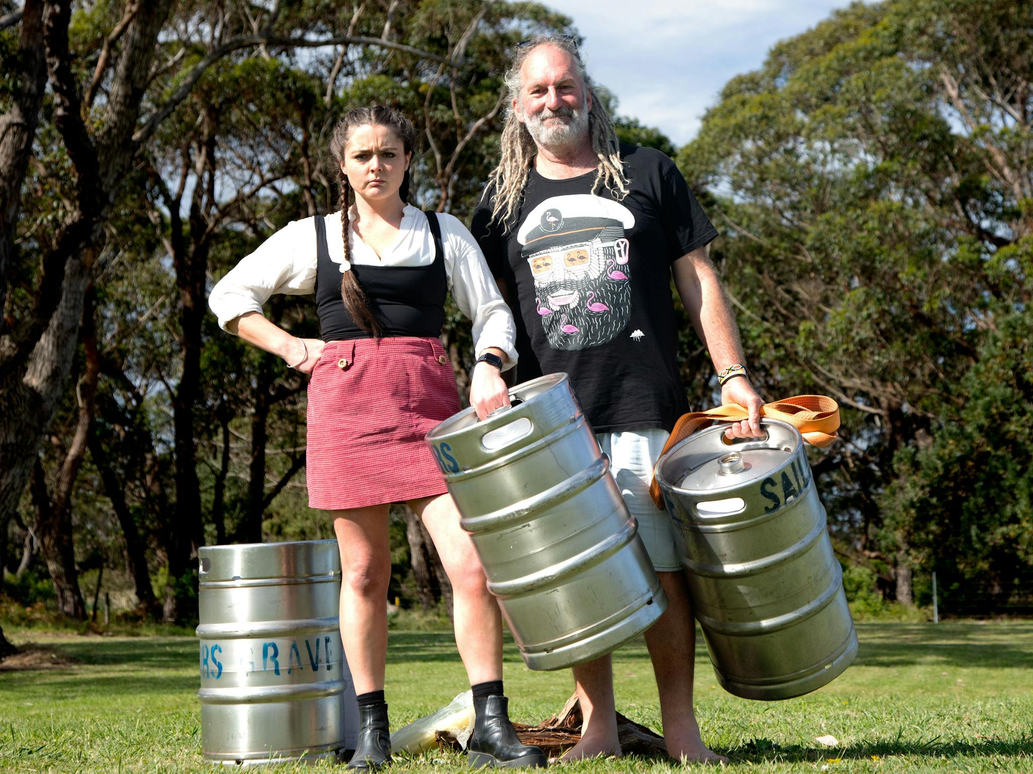 Two peole holding kegs for keg-throwing competition