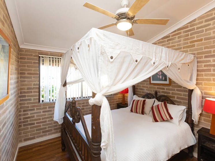 Master bedroom with 4 post bed with canopy, wooden ceiling fan with light