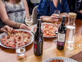 plates of pizza and bottles of wine on a table