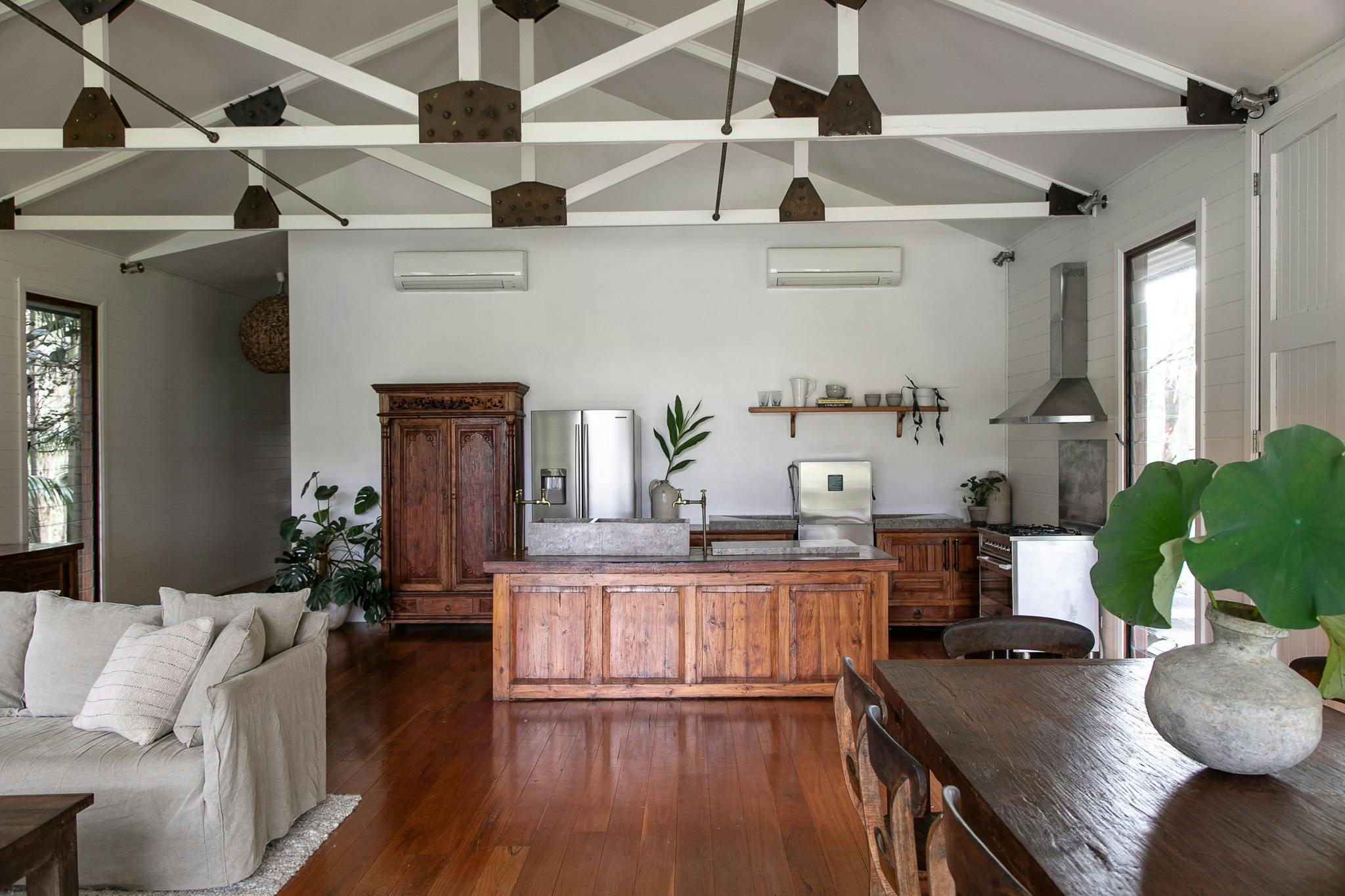 A large open plan living room with detailed beams and wooden accents
