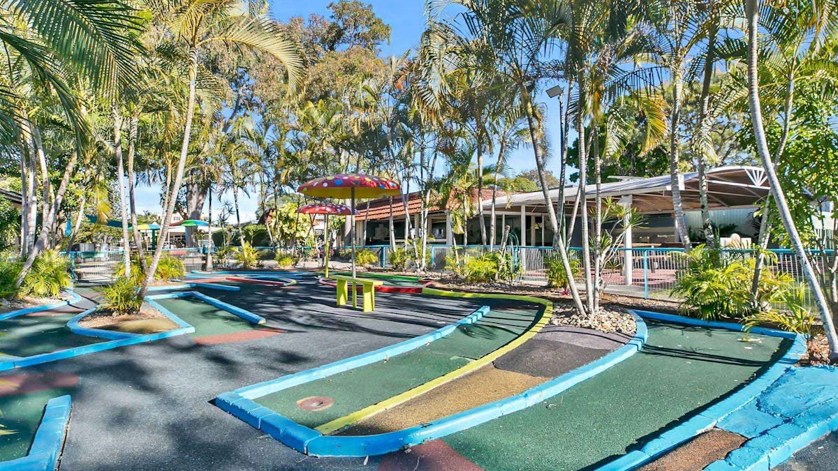 mini-golf course, surrounded by palm trees