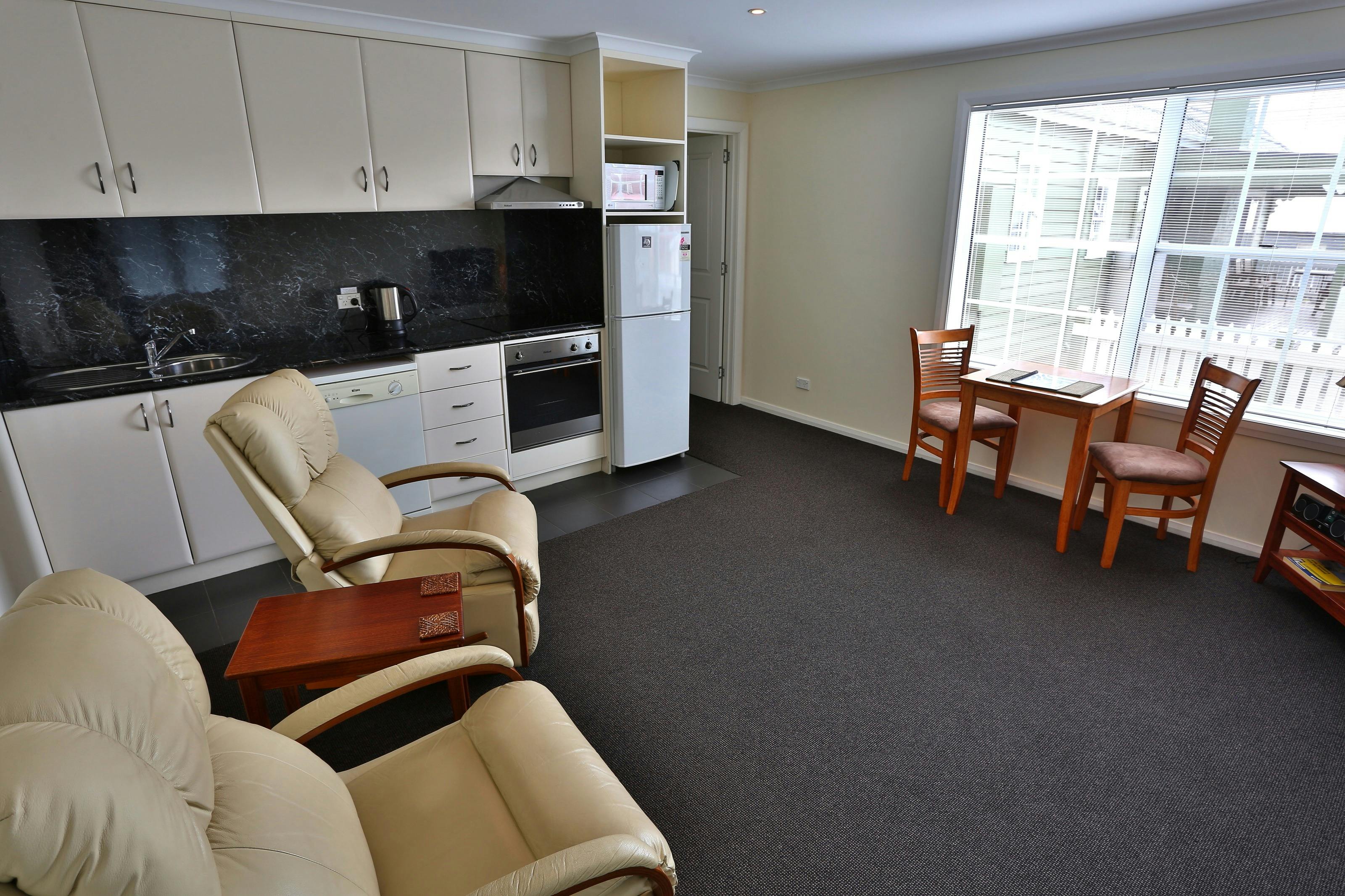 kitchen, dining, lounge area overlooking a sunny outside deck with views to The Nut