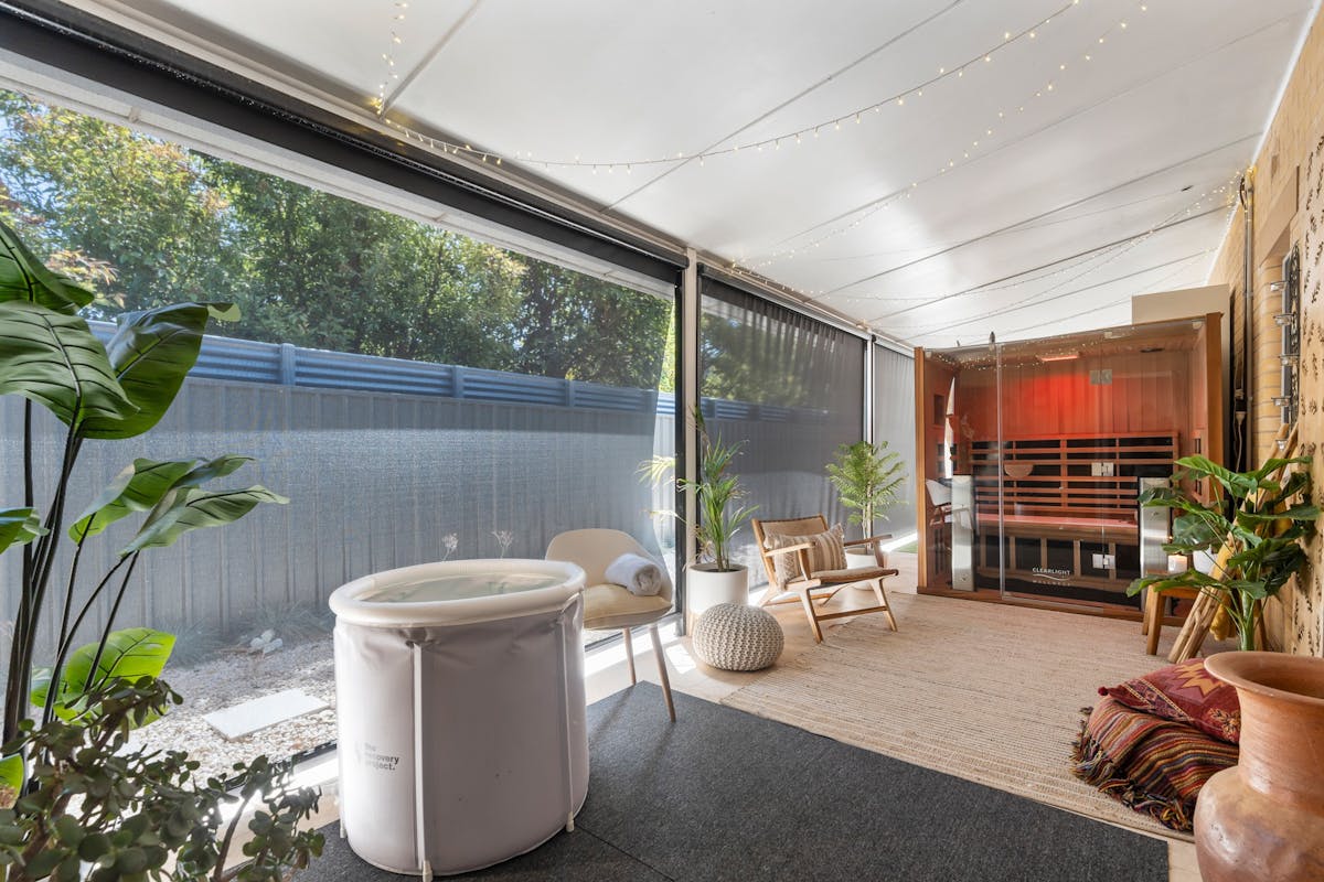 A warm treatment space featuring an ice bath and Far Infrared Sauna