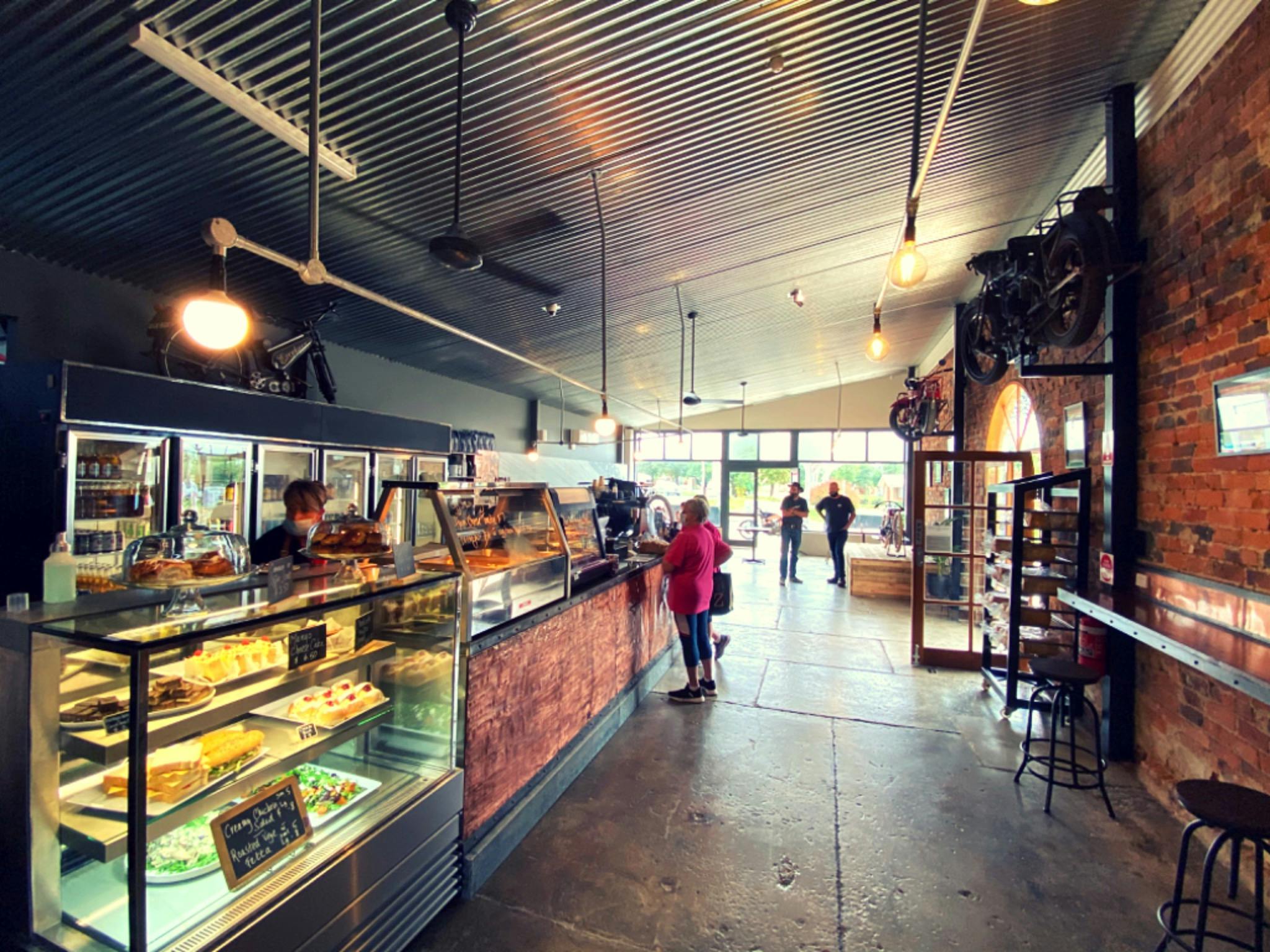 View of the main bakery cafe space, polished concrete floors, rustic brick walls