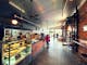 View of the main bakery cafe space, polished concrete floors, rustic brick walls