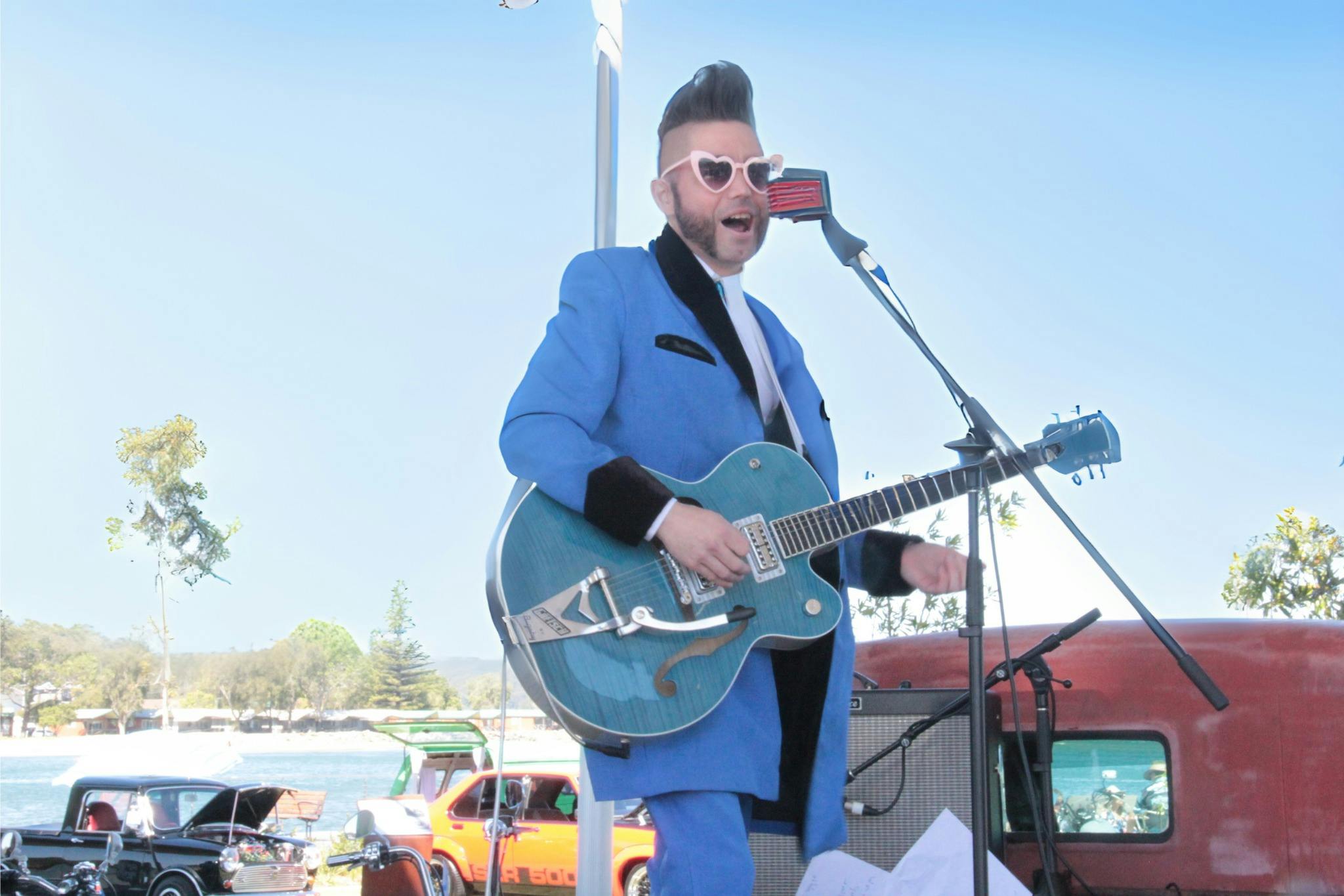 Rek Less playing guitar on stage