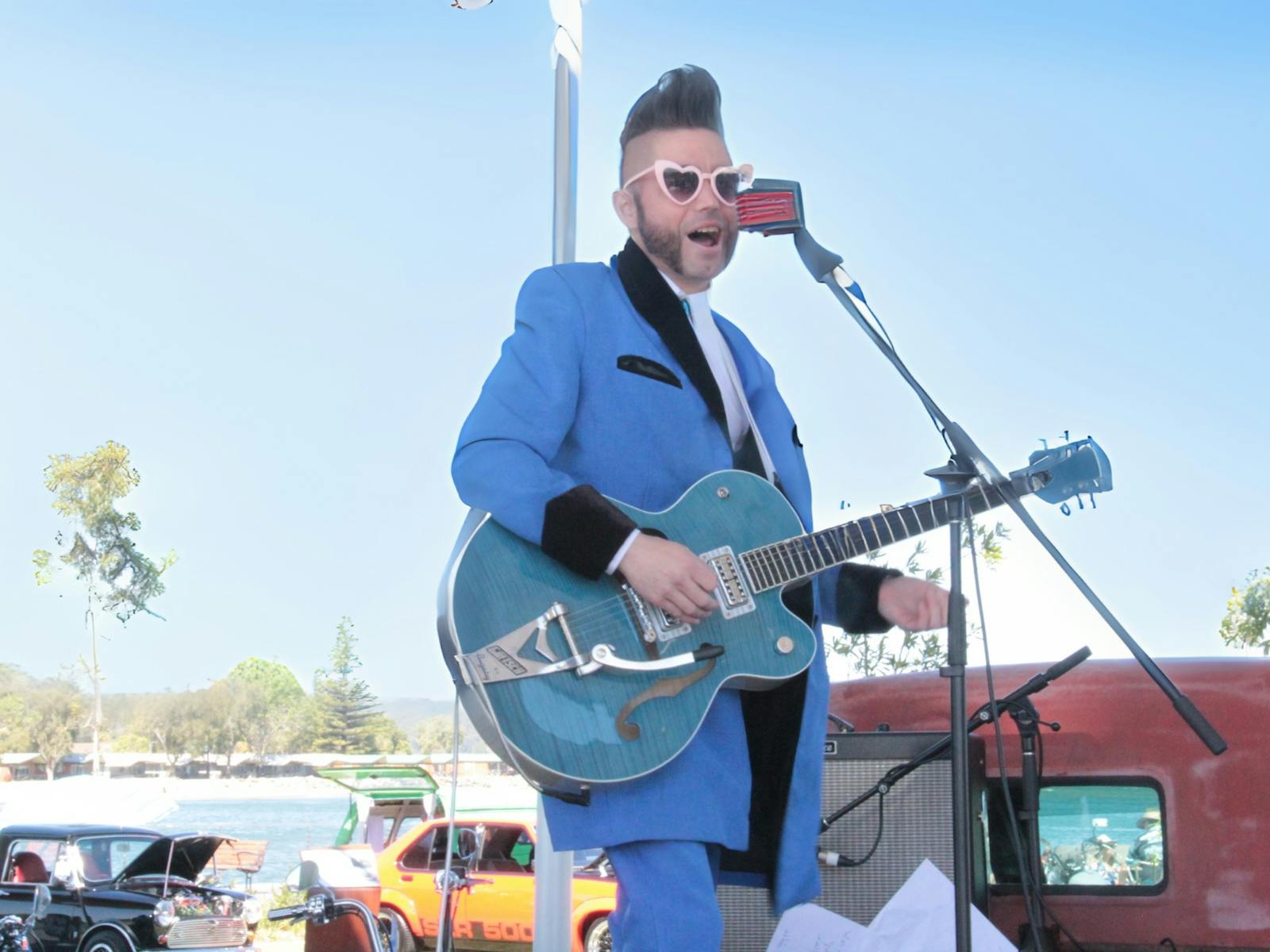 Rek Less playing guitar on stage