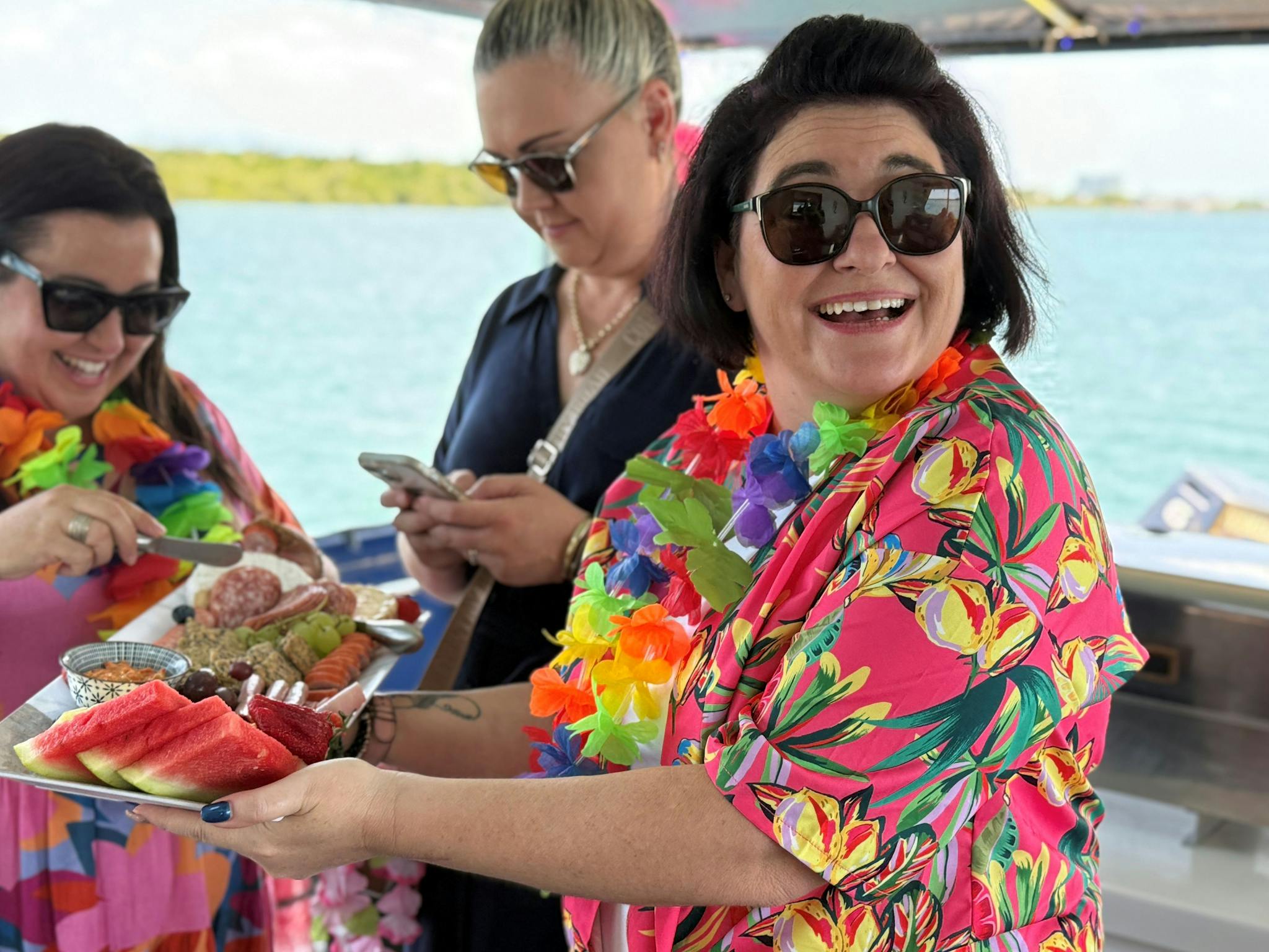 Guests in brightly coloured tropical shirts with grazing platter Guests in brightly coloured tropical shirts with grazing platter