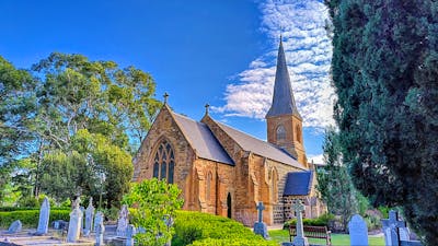 Ancient graveyard surrounding stone church with park and gardens