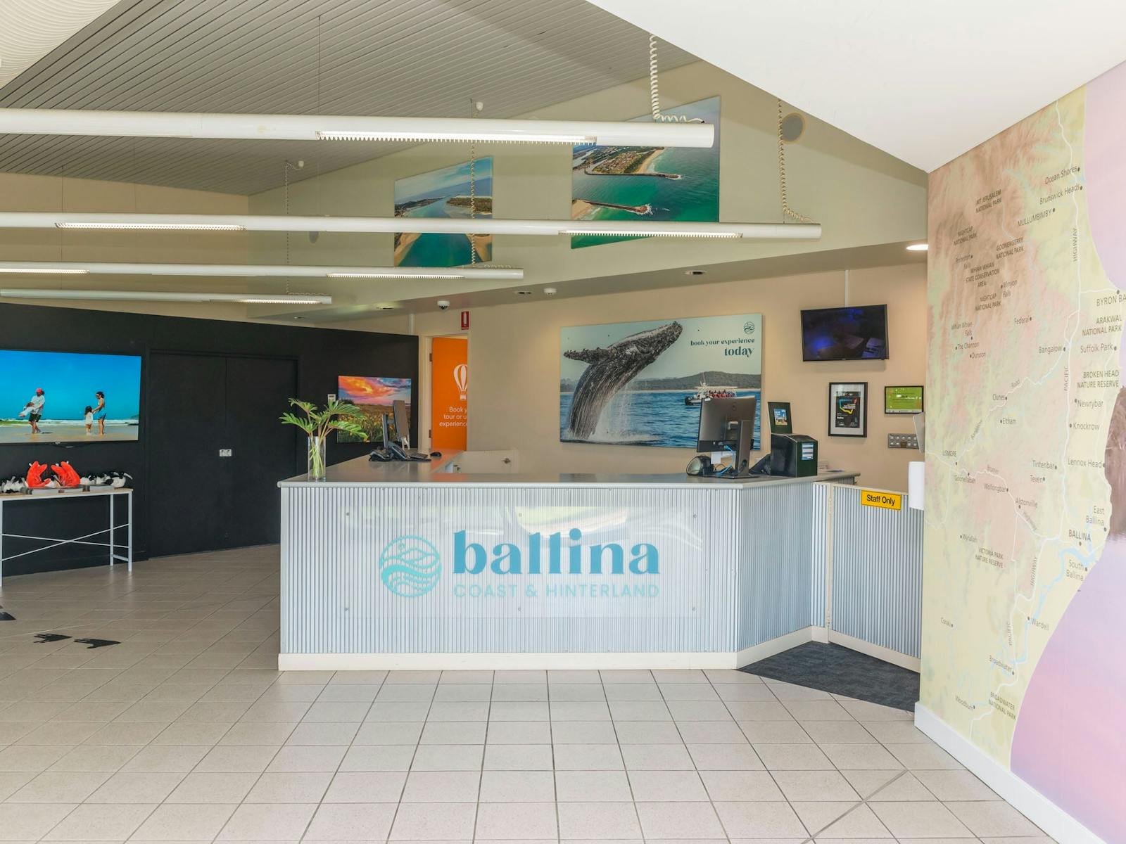 Interior of the centre with a large map on the wall, picture of a whale, tv and front counter