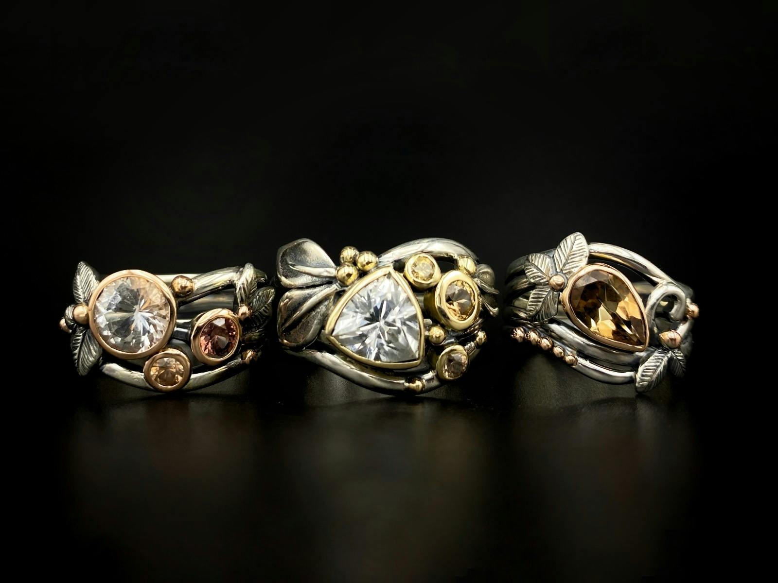 Three rings with gemstones and silver floral embellishments