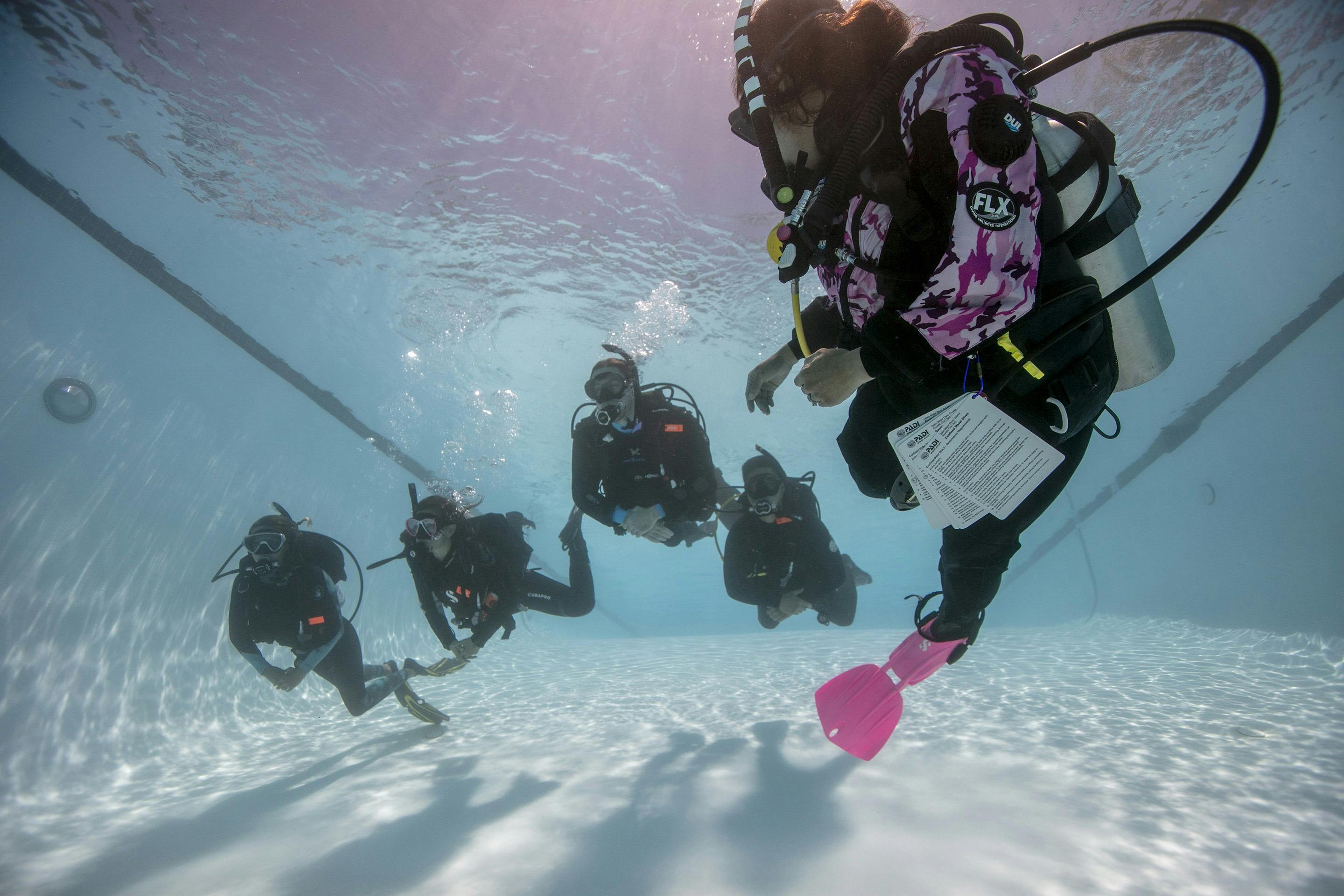 Scuba diving students in pool with instructor