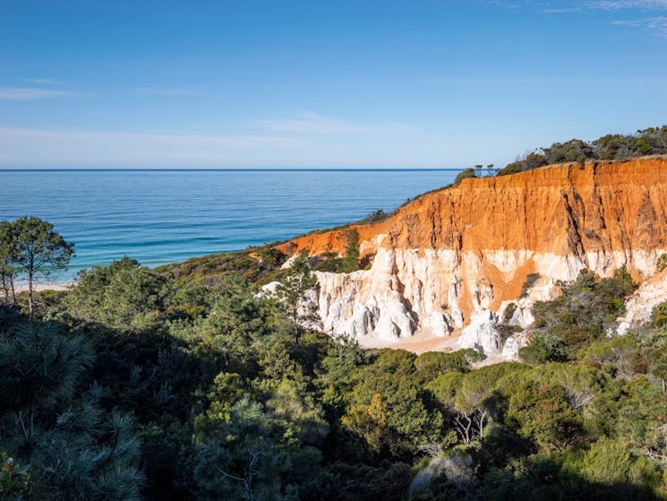 Blue sky and ocean contrast against the white and orange rocks at the Pinnacles Lookout