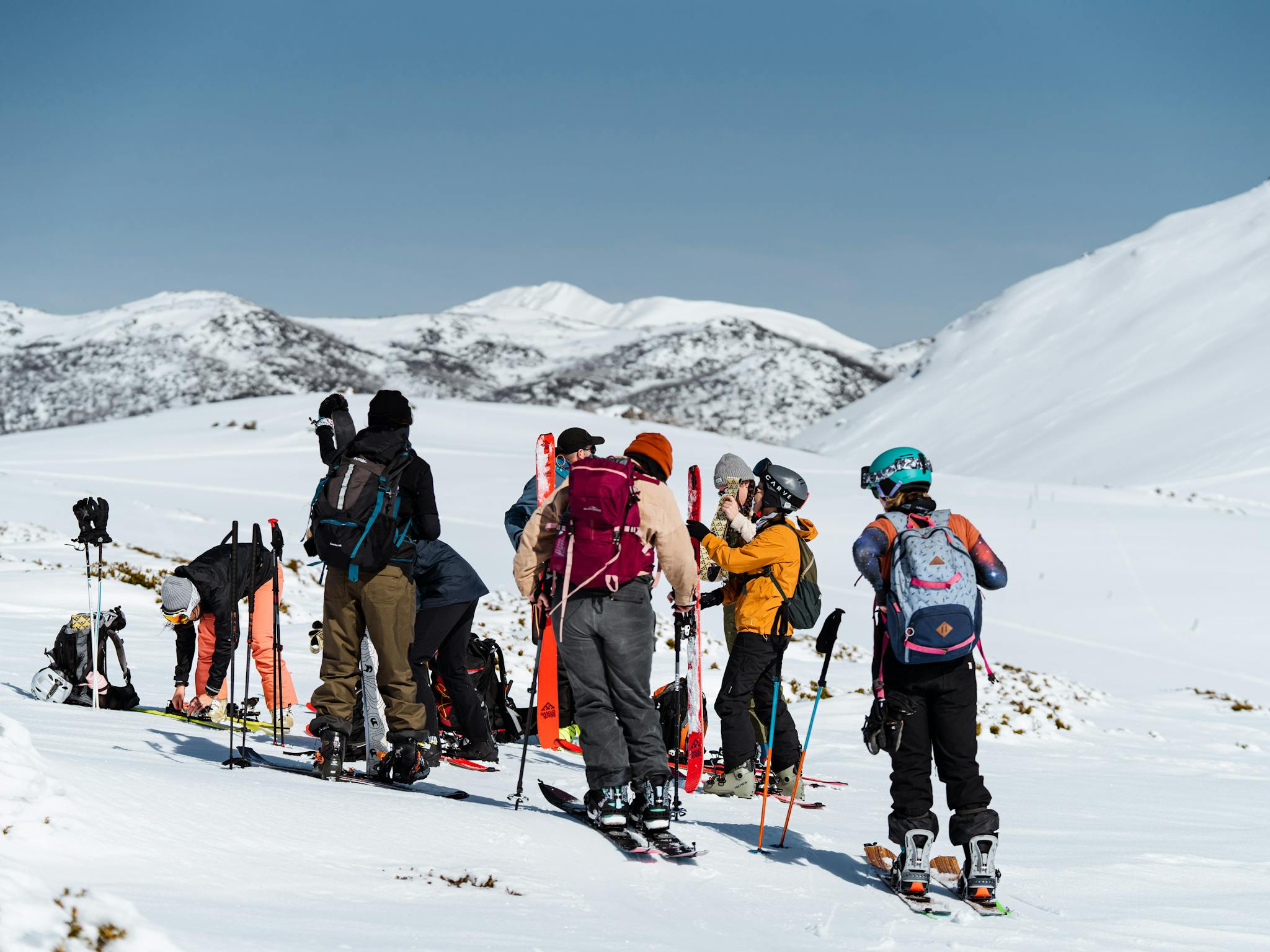 group on a snow capped mountain with snow gear and skis