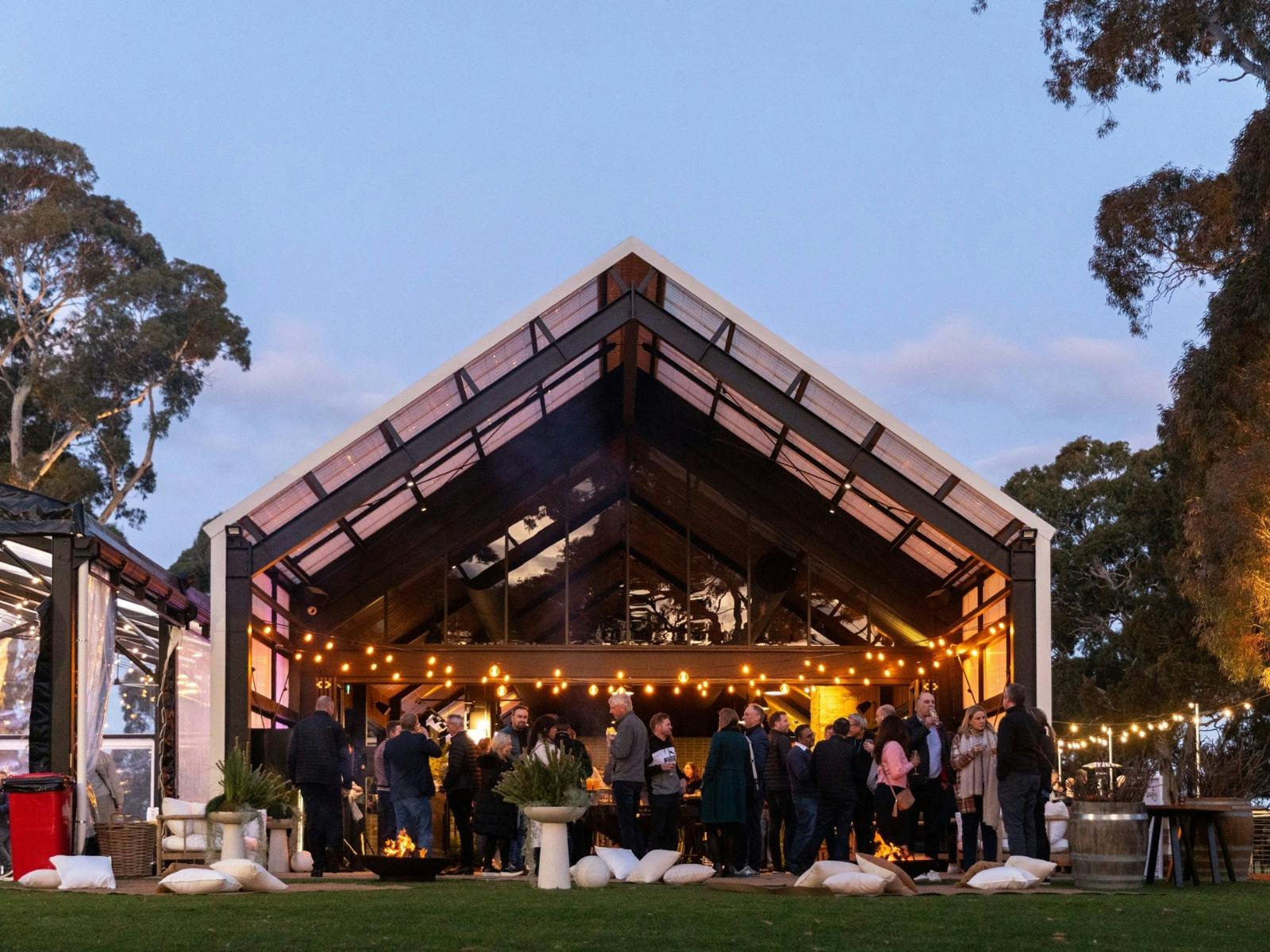 LOT.100 building at dusk with people standing around enjoying themselves