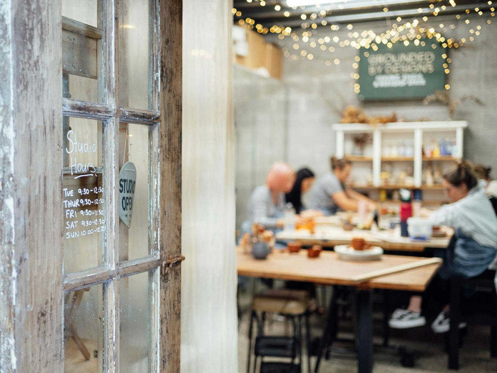 group of people blurred in the background working at the table with the rustic doors in focus