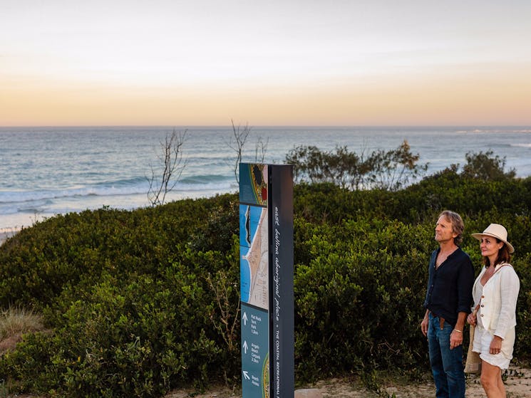 Viewing an interpretive panel at Sharpes Beach