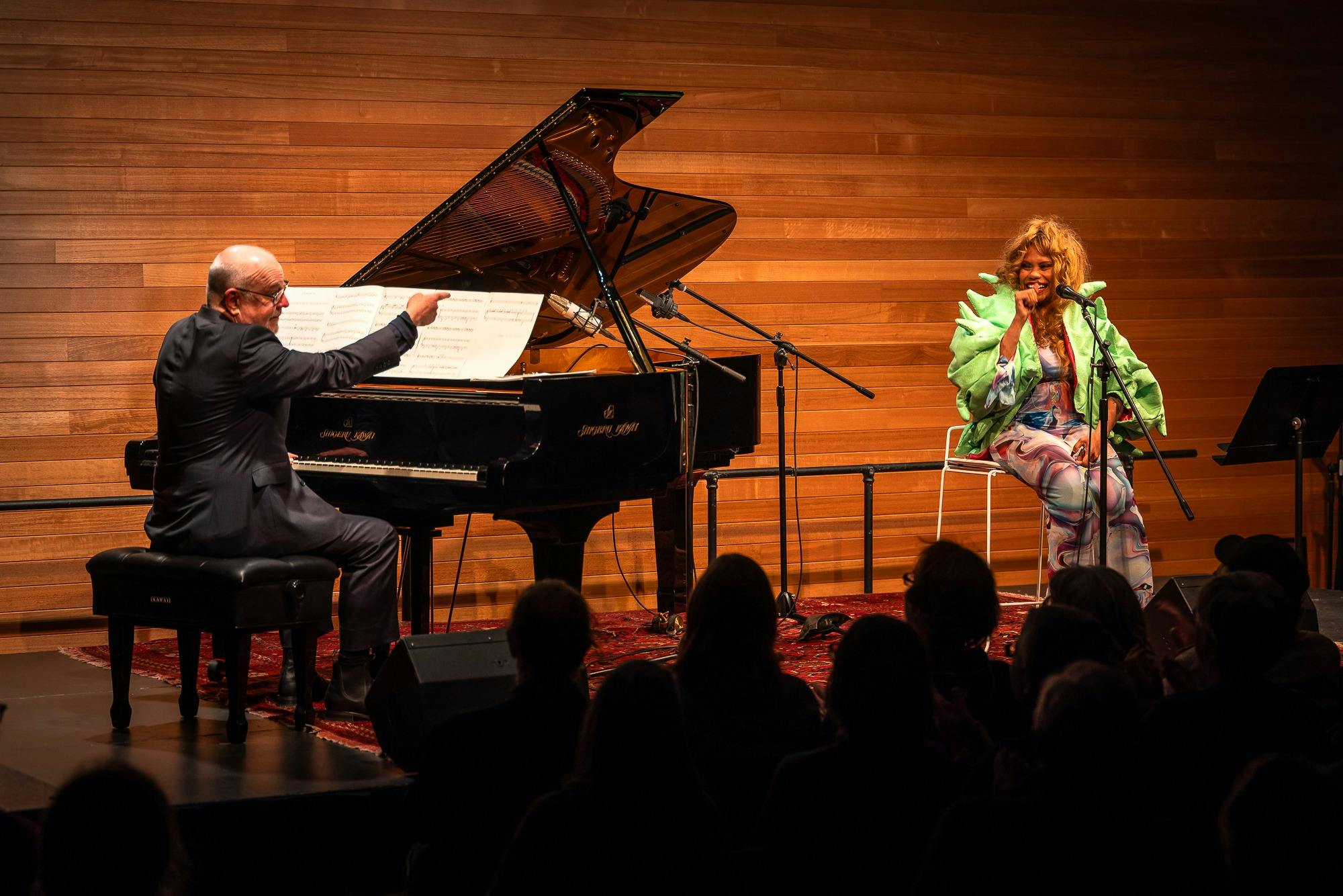 Pianist Paul Grabowsky sitting at a piano next to vocalist Ngaiire