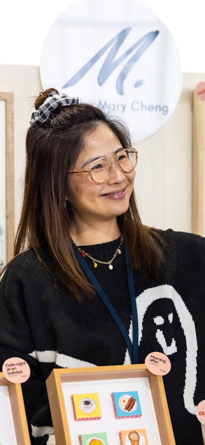 Mary Cheng Art handing a bag over to a customer