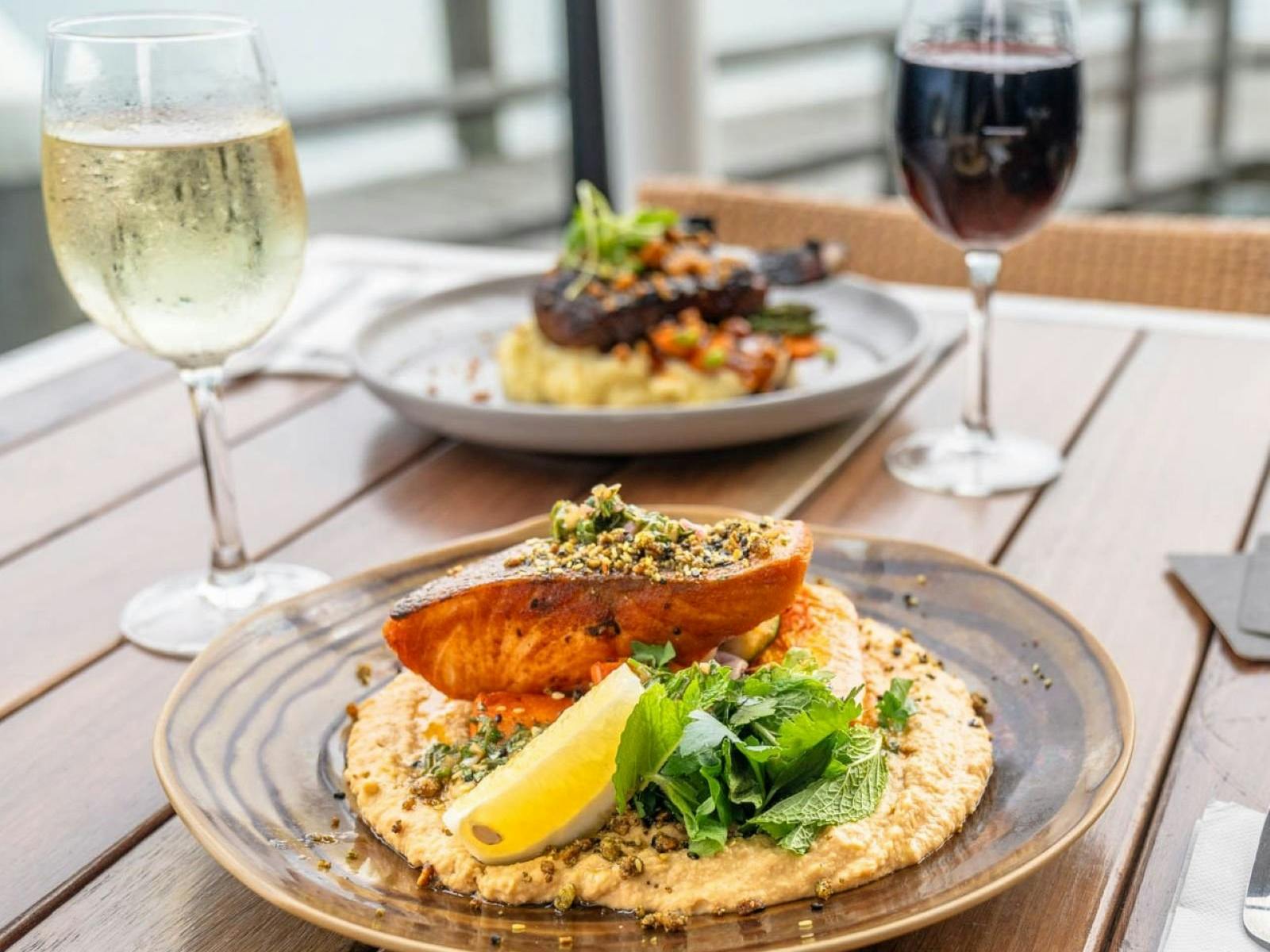 Salmon meal with mint and lemon and two glasses of wine