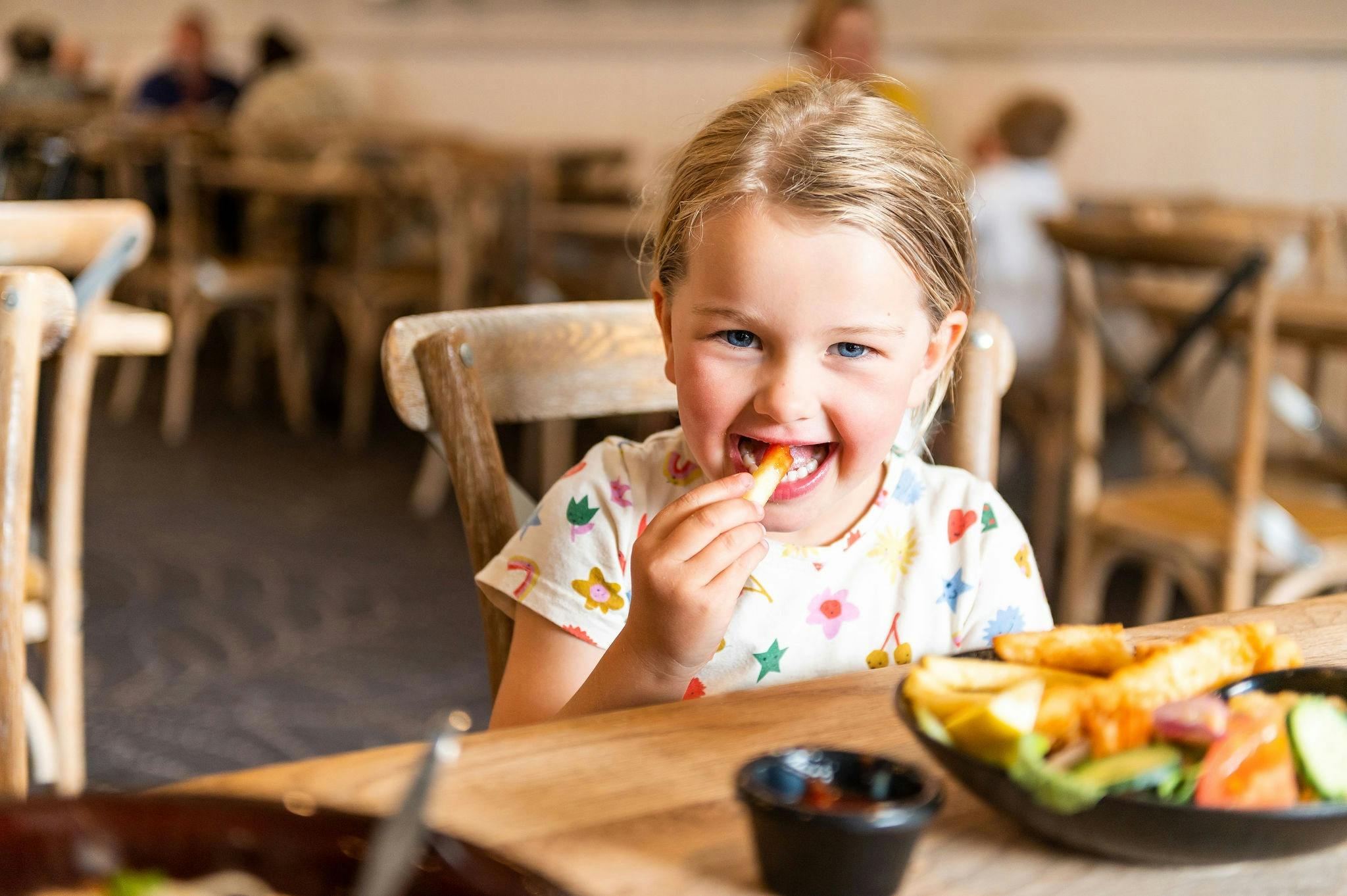 Young Girl smiling and eating potato chips
