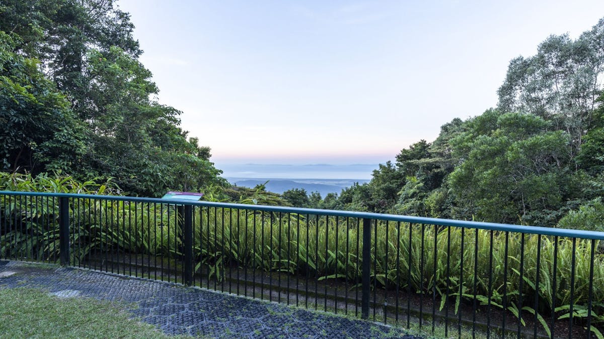 Lookout with a sign and view out over a valley to the ocean.