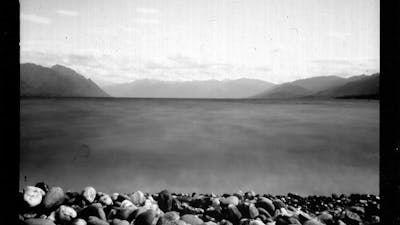 A black and white image of a body of water with a rocky beach