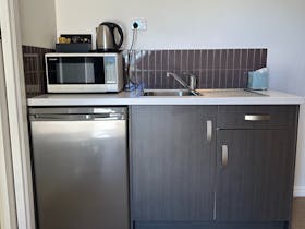 Kitchenette including microwave, fridge, sink and kettle in Parachilna Overflow Accommodation room