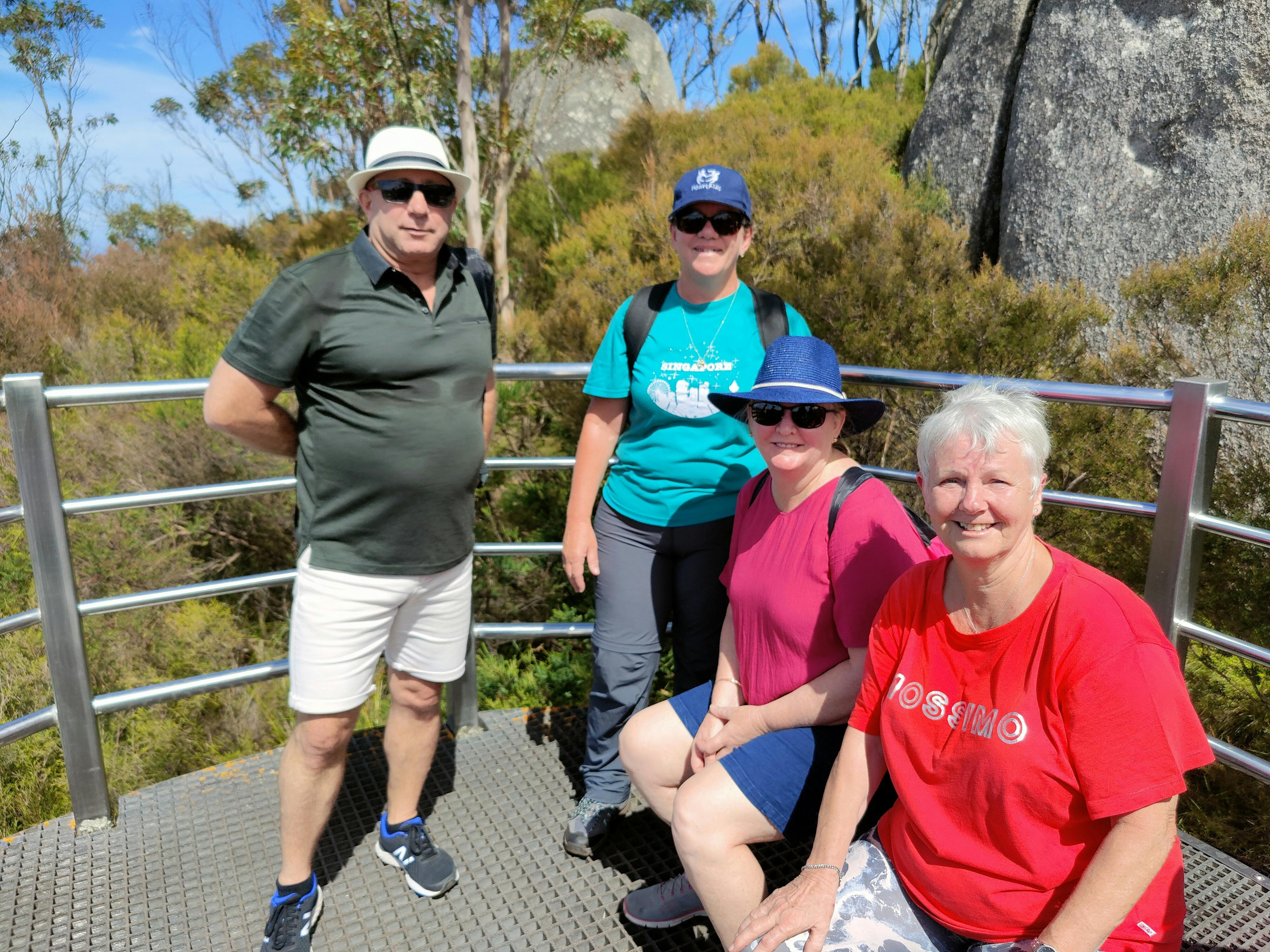 group of four people on deck platform in bushland setting