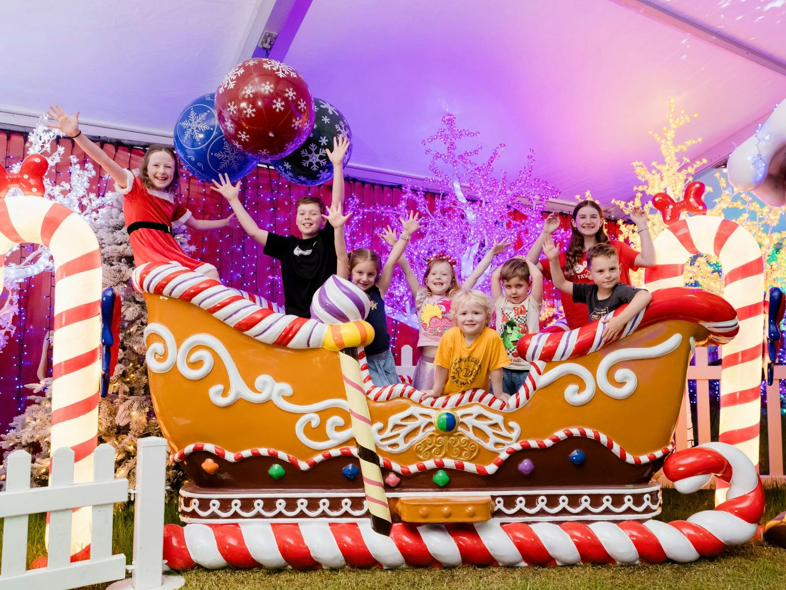 A group of happy children, sitting in a giant gingerbread sleigh