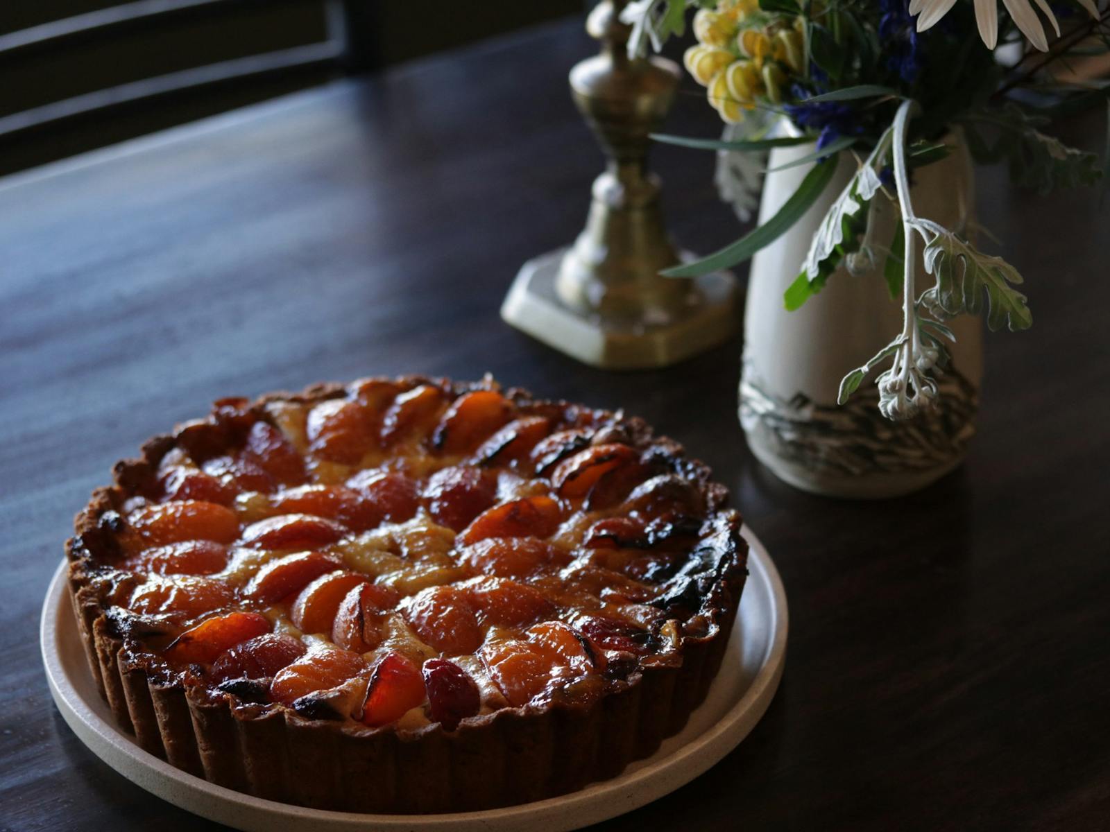 Caramelised Apricot tart with a candle Holder and Yellow Flowers