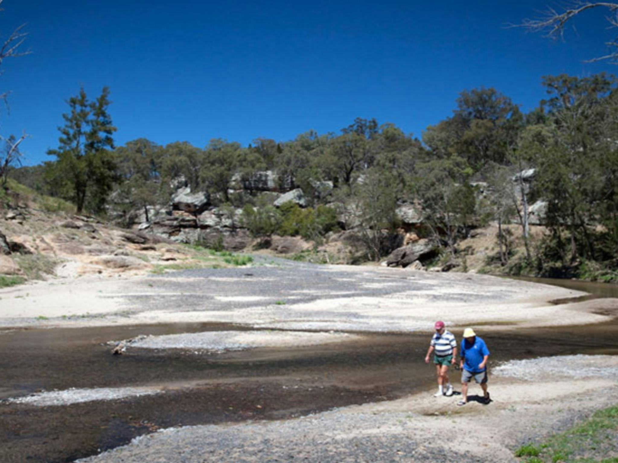 Two men walk along the Goulburn River at Big River campground, Goulburn River National Park. Photo:
