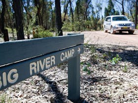 A sign towards Big River campground with a car in the background in Goulburn River National Park.