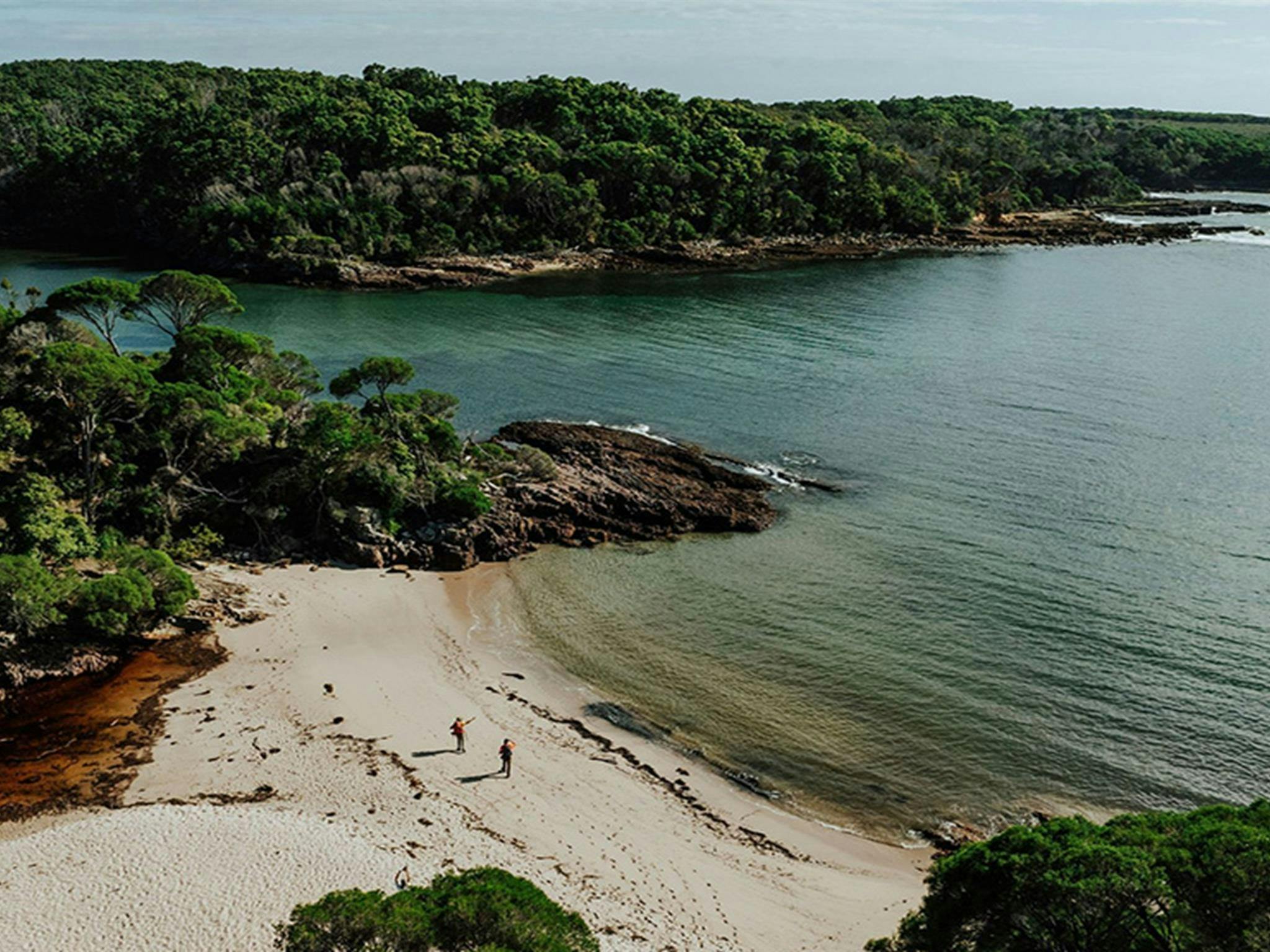 Luftaufnahme von zwei Wanderern in der Bittangabee-Bucht im Beowa-Nationalpark. Foto: Daniel Parsons/DCCEEW