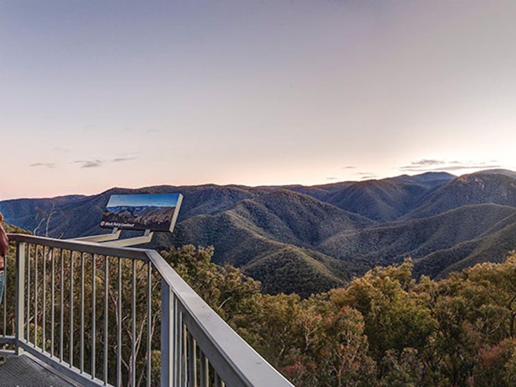 A woman stands next to a sign at Black Perry lookout, Kosciuszko National Park. Photo: Murray
