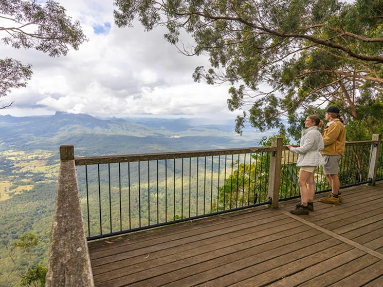 2 visitors looking at the view of Wollumbin - Mount Warning and Tweed Valley at Blackbutt lookout