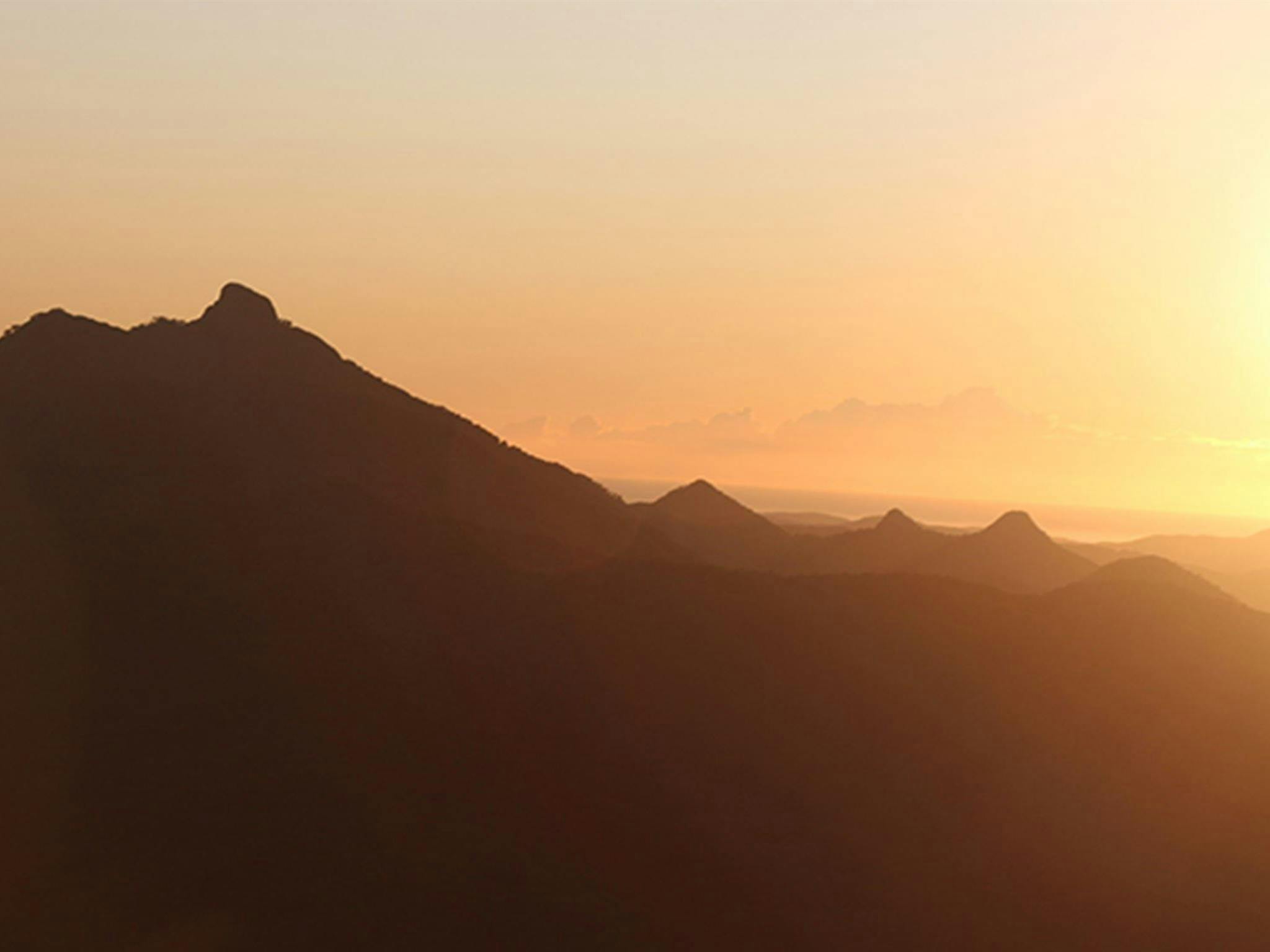 ブラックバットから見た、ツイード渓谷に太陽が昇るウォルンビン・マウント・ウォーニングのシルエット