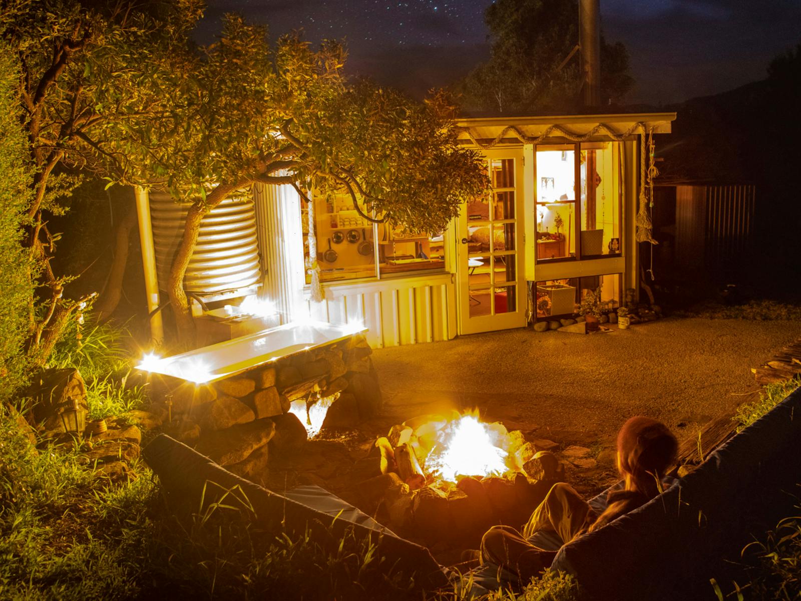Sit on the outdoor lounge waiting for the fire under the bath to heat the water.  The heated rocks keep the water warm.
