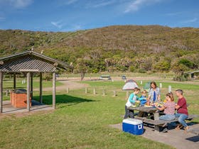 A family at a picnic table at The Ruins picnic area, Booti Booti National Park. Photo credit: John