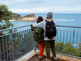 A couple at a lookout on Bouddi costal walk admiring ocean views. Photo:  Jared Lyons © DPE