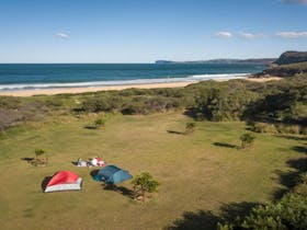 Aerial view of tents and ocean in the distance at Tallow Beach campground. Photo credit: John