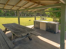 Picnic shelter with a picnic table and barbecue at Broken Head picnic area in Broken Head Nature