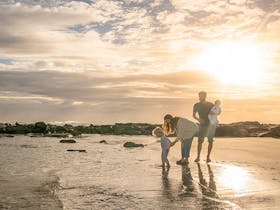 A family with young children on the beach at sunset, Bundjalung National Park.  Photo: John