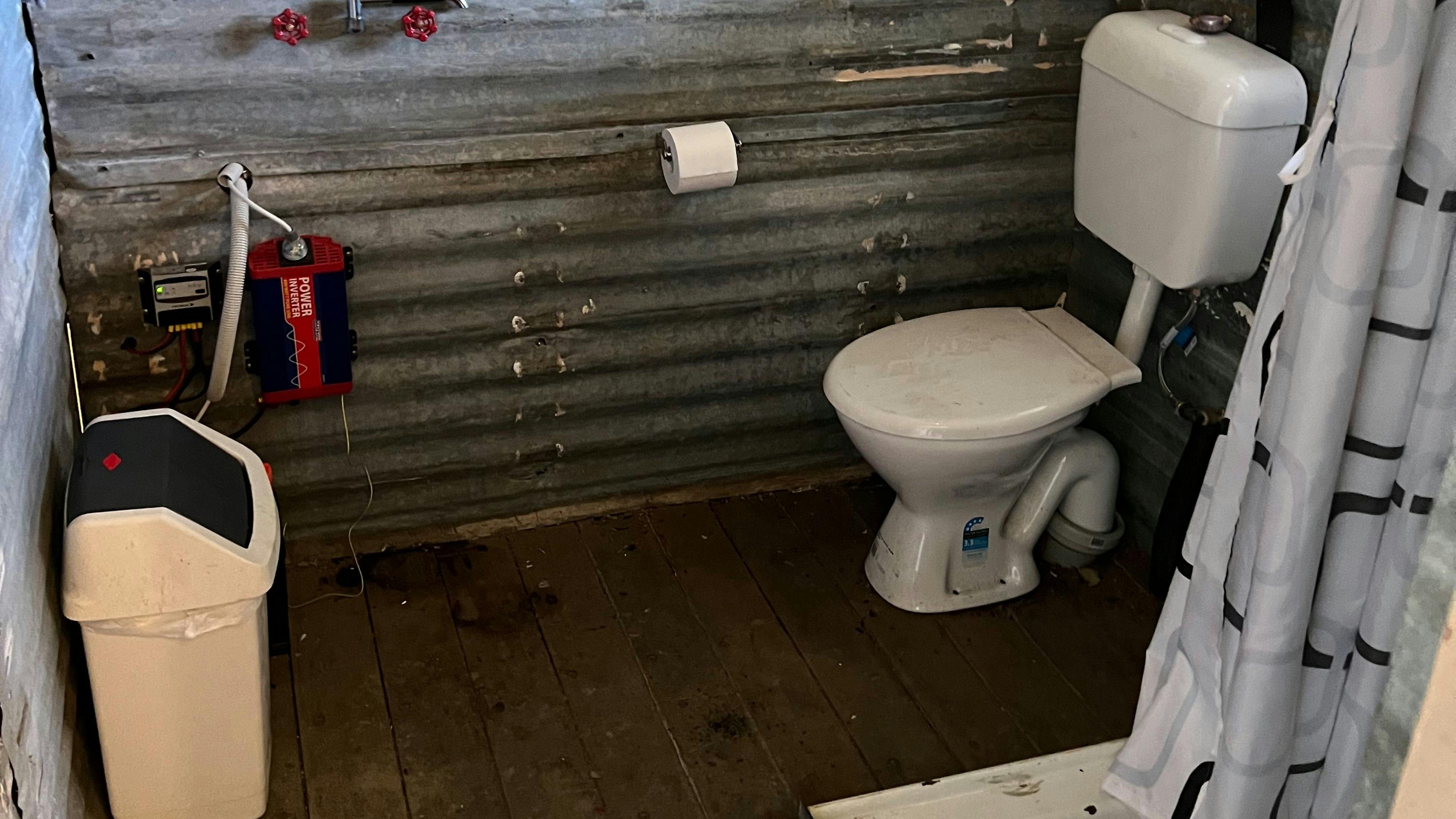 Bathroom with flushing toilet and gas hot water.