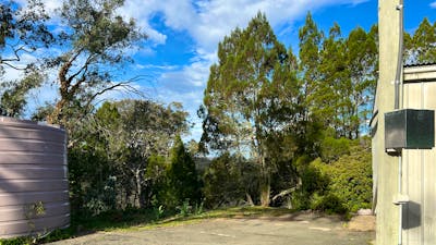This is the site, large asphelt area, near power supply, grass/dirt area of several metres at back of site. Large turning space in front of site. Back of site has view down into bush and ove