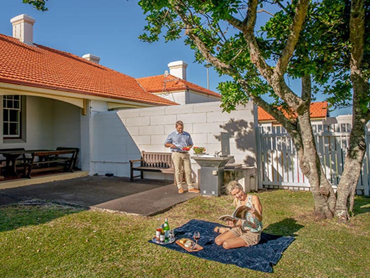 Couple having a picnic barbecue on the lawn of the Assistant Lighthouse Keepers Cottage. John